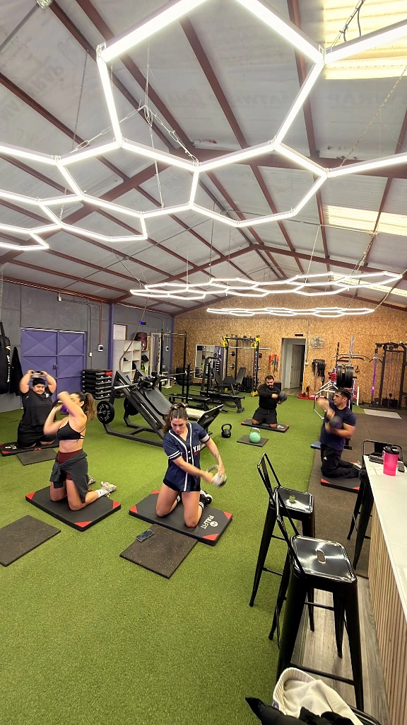 Área de fuerza en Glow Up, atletas entrenando con mancuernas